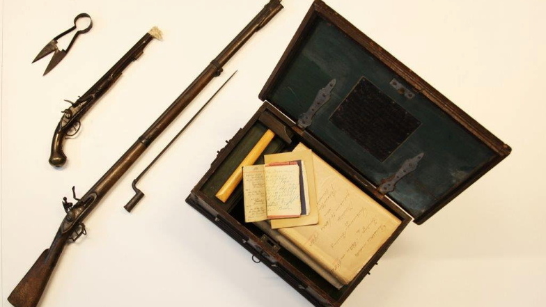Einige Gegenstände, die beim Einbruch in das Heimatmuseum gestohlen worden waren: ein Gewehr, eine Pistole und eine Zunfttruhe.