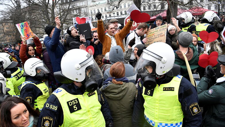Bereitschaftspolizisten stehen in Malmö auf einer Straße bei einer Demonstration gegen die Maßnahmen zur Eindämmung des Coronavirus.