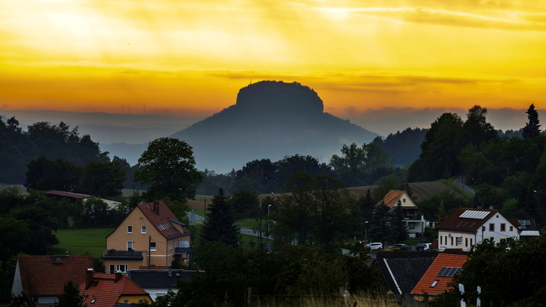 Die Sonne geht nach einem Spätsommertag malerisch über der Felsenlandschaft der Sächsischen Schweiz unter, im Hintergrund der Lilienstein.