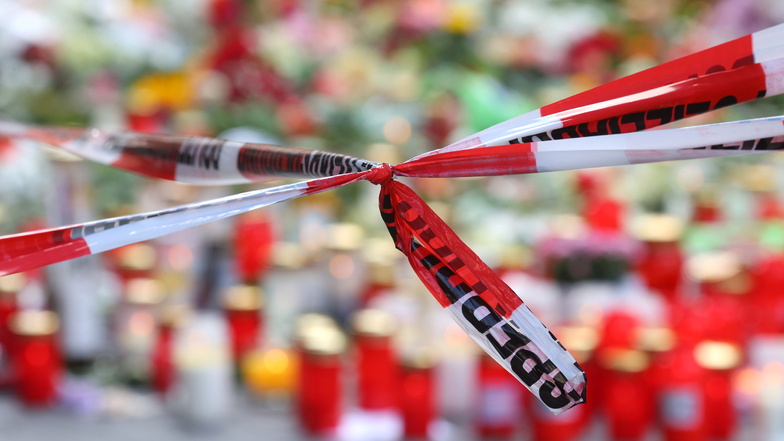 Würzburg: Blumen und Kerzen vor einem abgesperrten Kaufhaus, in dem ein Mann Menschen mit einem Messer attackiert hatte. Bei dem Angriff am 25.06.2021 hatte ein Somalier drei Frauen in einem Kaufhaus getötet.