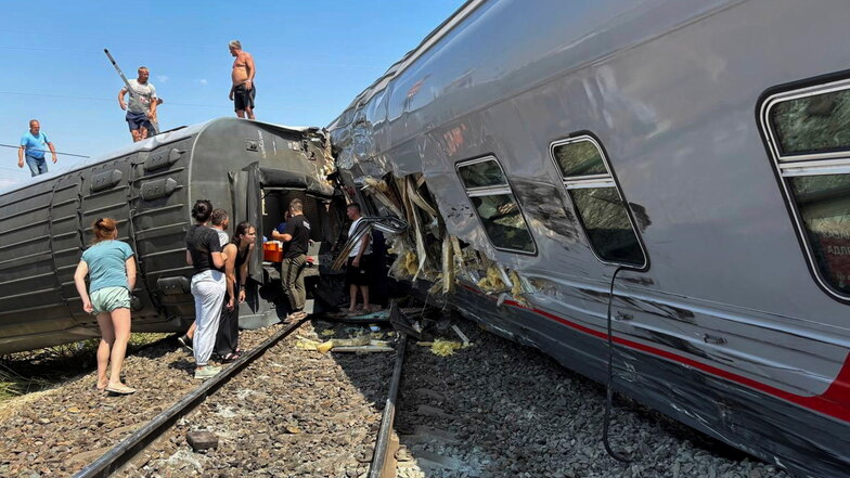 Auf diesem von der Bezirksverwaltung Kotelnikowskij veröffentlichten Foto sind Fahrgäste an der Stelle zu sehen, an der ein Personenzug entgleist ist.