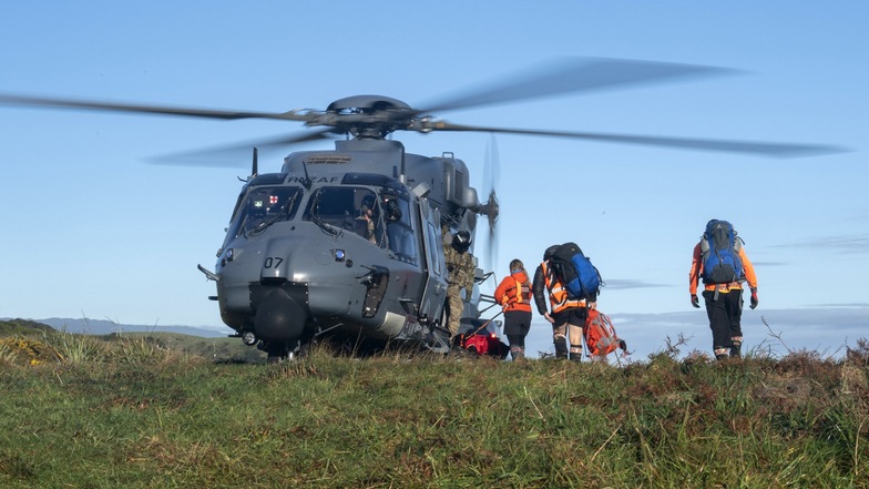 Neuseeland, Kahurangi National Park: Rettungshelfer gehen während eines Einsatzes an Bord eines Hubschraubers.
