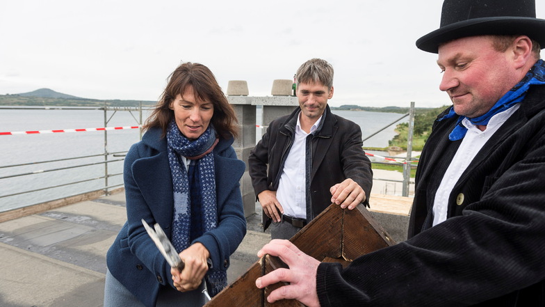 Ina Lachmann und Henry Hedrich (Mitte) gemeinsam mit Martin Glaeser von der G.M.V. Dachbau GmbH bei der Grundsteinlegung für das Hotel "Insel der Sinne" am Berzdofer See.
