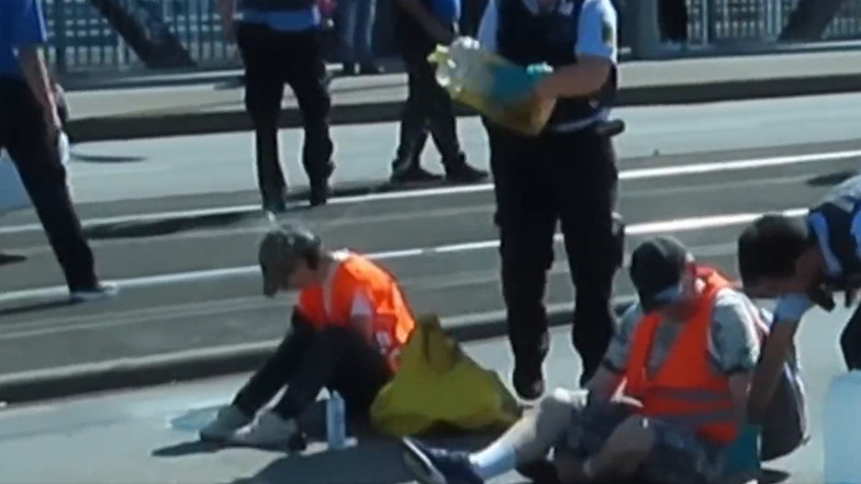 Polizistin schüttet Öl auf Klima-Demonstranten
