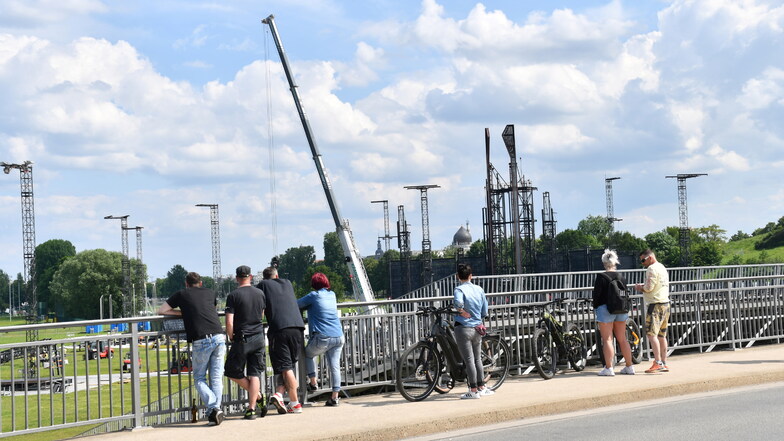 Einige Dresdner und Rammstein-Fans beobachten den Aufbau der Kulisse von der Schlachthofbrücke aus.