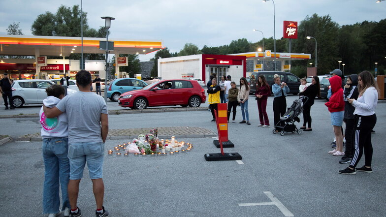 Menschen stehen neben Blumen und Kerzen nahe einer Tankstelle in Botkyrka. Ein zwölfjähriges Mädchen dort Anfang August 2020 angeschossen worden und später ihren Verletzungen erlegen.