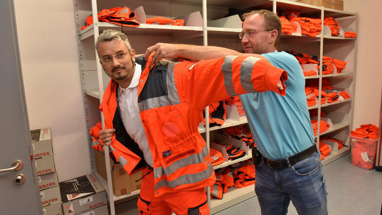 Der Praktikant wird eingekleidet: Rettungswachenleiter Jan Göbel verpasst Reporter Jörg Stock die orange Einsatzkluft der Sanitäter.