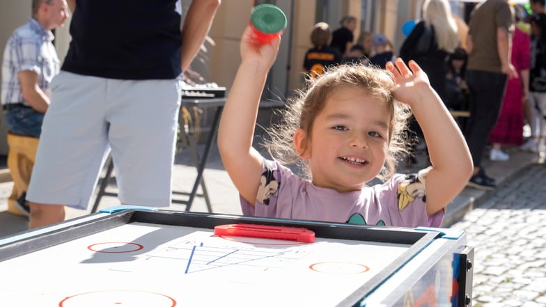 Beim Jakobstraßenfest freut sich Melaniia mit ihren drei Jahren über einen Punkt beim Air-Hockey.