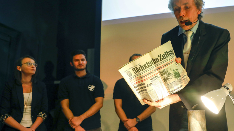 Hochschulmitarbeiter Dr. Wolfgang Menzel holt die Zeitdokumente von der Grundsteinlegung des Gebäudes aus der Kupferhülse - hier gerade die Sächsische Zeitung.