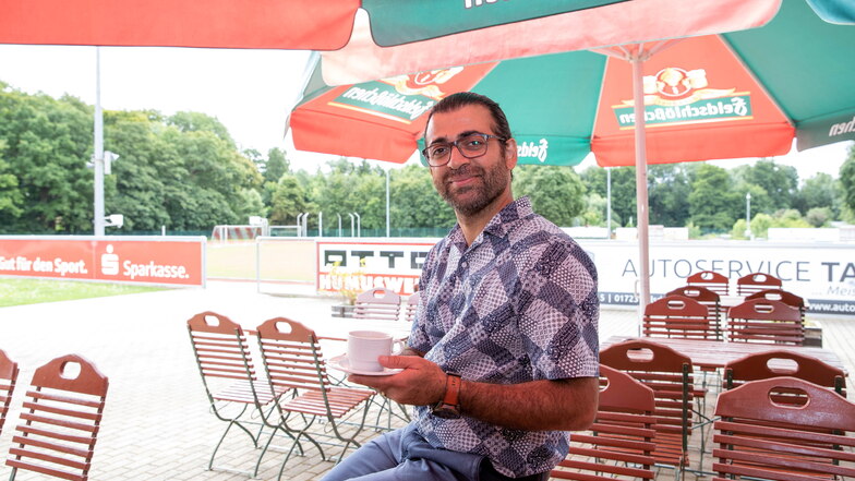 Mustafa Yalçinkaya (36) ist der neue Betreiber der Gaststätte am Parkstadion in Wilsdruff. Auf dem Foto sitzt er auf dem Tisch seines Biergartens.