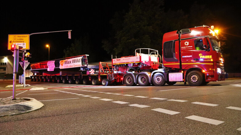 Ein Schwertransporter mit einem Stahlbauteil für eine neue Brücke ist in der Nacht unterwegs.