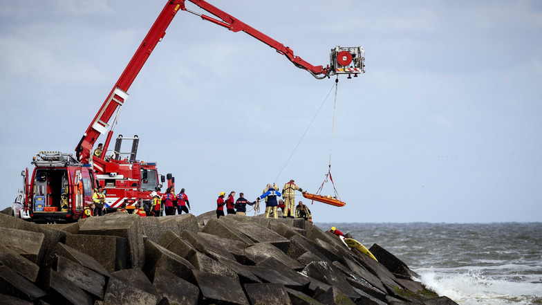 Niederlande, Scheveningen: Rettungskräfte bergen eine Leiche, die sie bei der erneuten Suche nach den vermissten Wassersportlern im Noordelijk Havenhoofd gefunden haben.