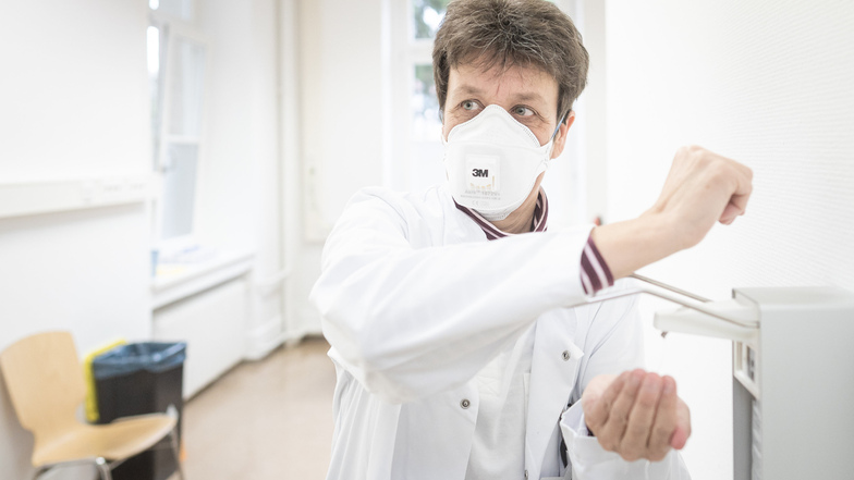 In der neuen Dresdner Corona-Ambulanz desinfiziert sich eine Ärztin am Montag die Hände. Das Universitätsklinikum bittet derzeit darum, die Krankenbesuche in allen Abteilungen zu reduzieren.
