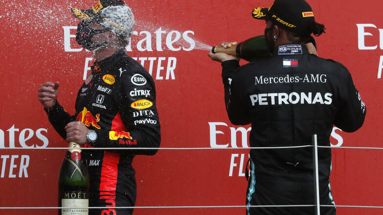 Champagner-Dusche mit Maske: Max Verstappen (l.) feiert seinen überraschenden Erfolg beim Rennen in Silverstone. Dem WM-Dominator Lewis Hamilton bleibt diesmal nur der zweite Platz.