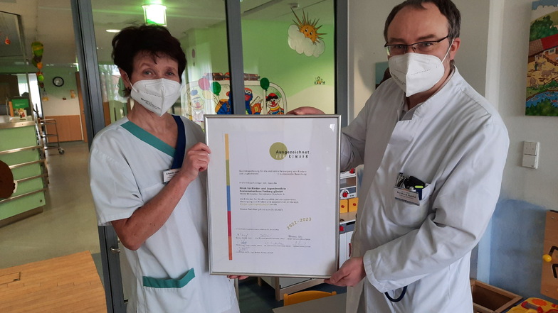 Stellvertretend für das gesamte Team zeigen Chefarzt Dr. Burkhard Matthé und Stationsleiterin Anett Pertuch das Zertifikat "Ausgezeichnet. Für Kinder."