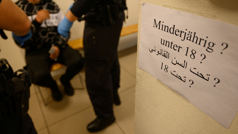 Ein Zettel mit der Frage nach der Minderjährigkeit klebt in deutscher und arabischer Sprache im Ankunftsbereich für Geflüchtete im Dresdner Hauptbahnhof.
