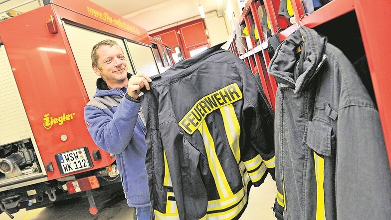 Ausgedient hat die Schutzkleidung der Feuerwehr in Weißkeißel, wie Ronny Scholz zeigt. Neue Uniformen sind bereits bestellt.