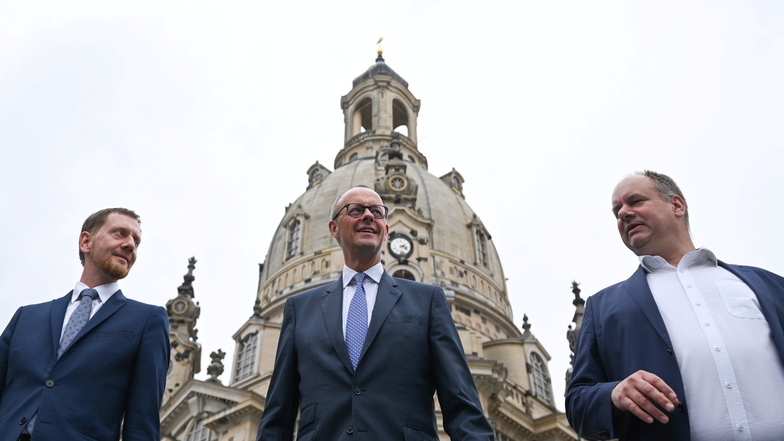 Sachsens MP Michael Kretschmer (CDU, l..), CDU-Chef Friedrich Merz (M) und Dresdens OB Dirk Hilbert (FDP) vor der Frauenkirche in Dresden