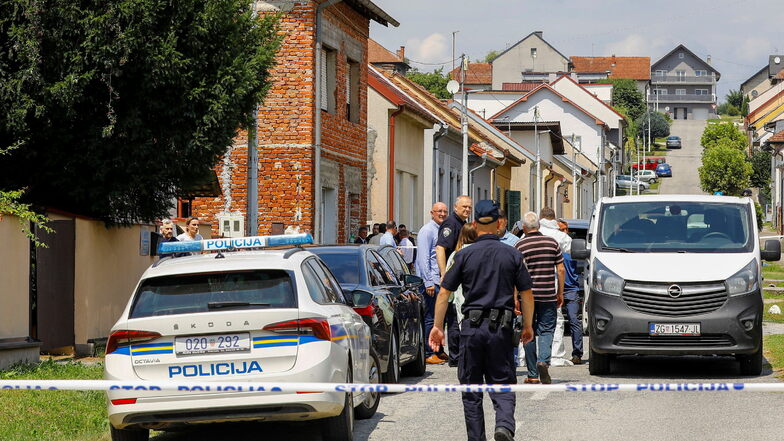 Polizei und Gerichtsmediziner stehen in der Nähe des Tatorts.