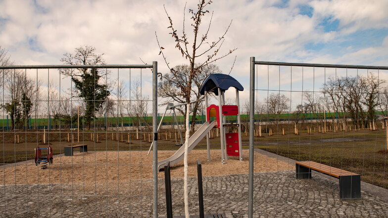 Bauzäune schützen noch immer den neuen kleinen Park in Zschieschen mit seinen Pflanzungen und Spielgeräten.