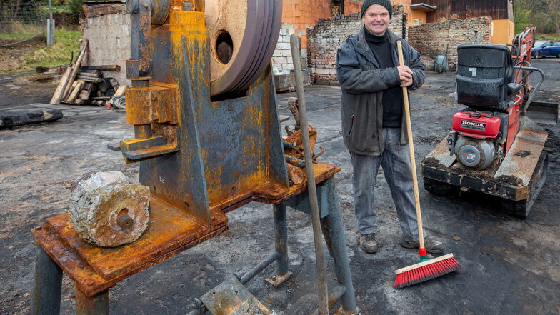 Klaus Michalik steht neben der Holzhackmaschine, die den Brand offenbar ganz gut überstanden hat und mit der er bald wieder arbeiten möchte.