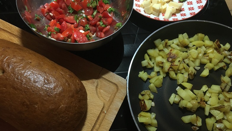 Bratkartoffeln, Käse, Brot und Rohkost ergeben ein buntes Abendessen.