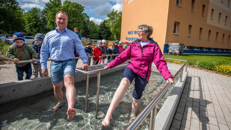 Tino Hüttner, Vorstand der Wohnungsgenossenschaft Fortschritt, und Karin Willkommen haben am Dienstag das Kneippbecken in Döbeln Ost eingeweiht.