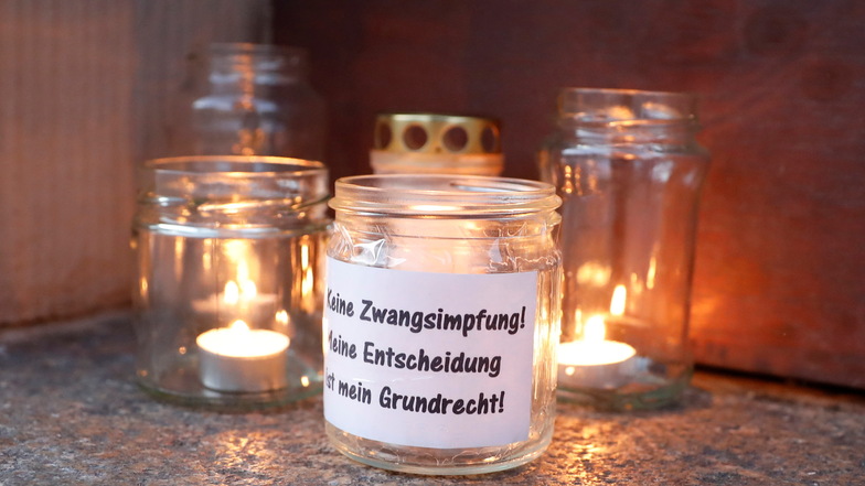 "Keine Zwangsimpfung" steht auf einer der Kerzen, die Teilnehmer der Montagsdemo in Löbau abgestellt haben.