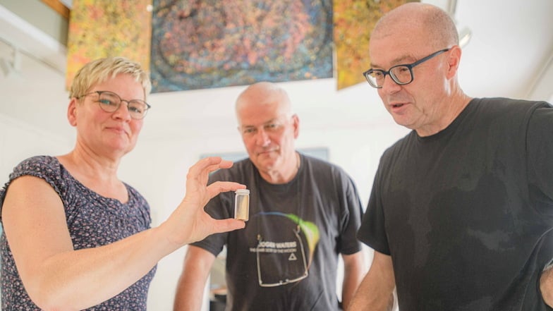 Neugierig und erstaunt schauen  Cathérine Schäfer, Martin Kaden und Jan-Michael Lange (v. l. n. r.) auf ein Fläschchen. darin ist Gold aus der Elbe