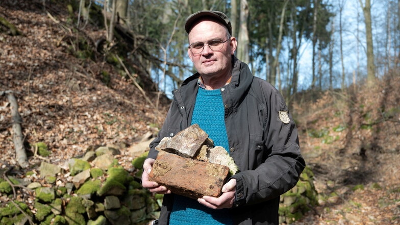 Der Archäologe zeigt einen herausgebrochenen Mauerbrocken mit einem handgeformten Ziegelstein, der vermutlich aus dem 15. Jahrhundert stammt.