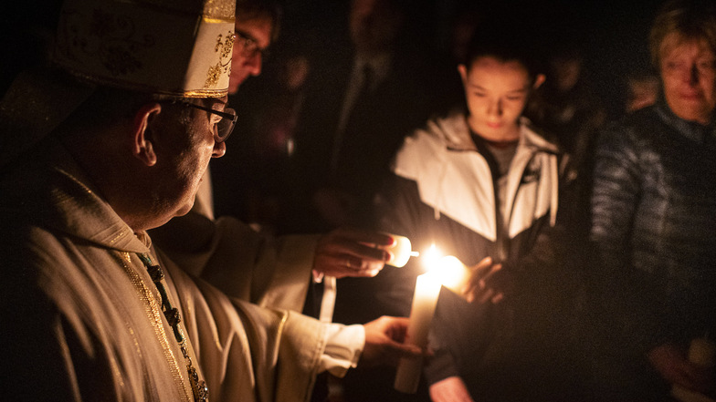 Osterfeuer in der St. Jakobus Kathedrale. Bischof Wolfgang Ipolt spendet Feuer zum Anzünden der Kerzen bei einer Messe in Görlitz