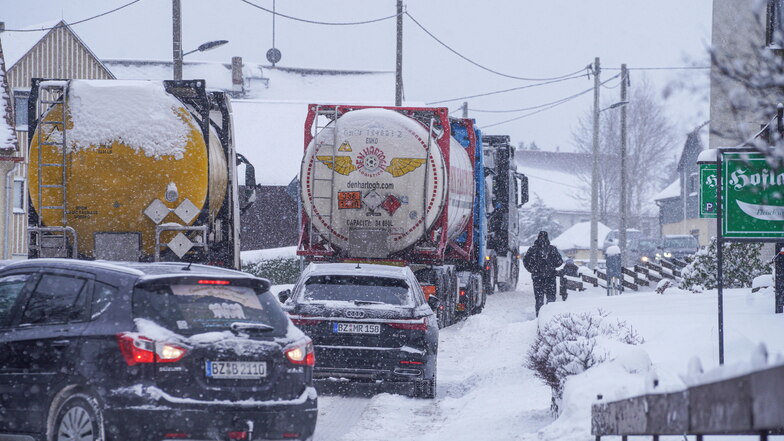 Lkw blockieren auf schneeglatter Straße am Vormittag die Ortsdurchfahrt in Steinigtwolmsdorf, sie waren an der Steigung aus Richtung Ringenhain liegen geblieben.