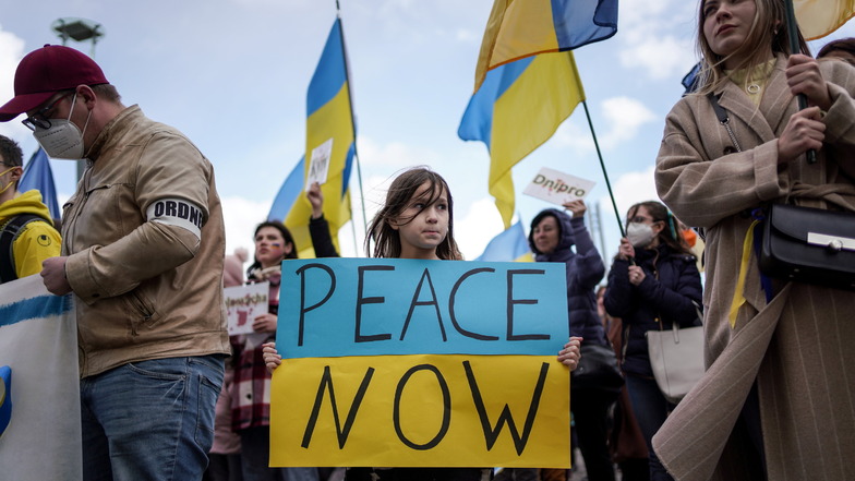 Ukraine-Demo in Dresden gegen den Krieg und für
Frieden. Mina Stahr (7) hält ihr Schild "PEACE
NOW" hoch.