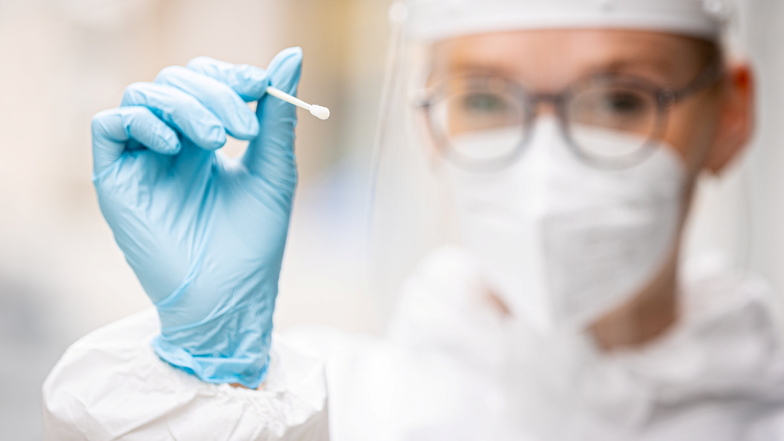 Die Mitarbeiterin eines Testzentrums hält einen Teststab für einen Schnelltest auf das Coronavirus in ihren Händen.