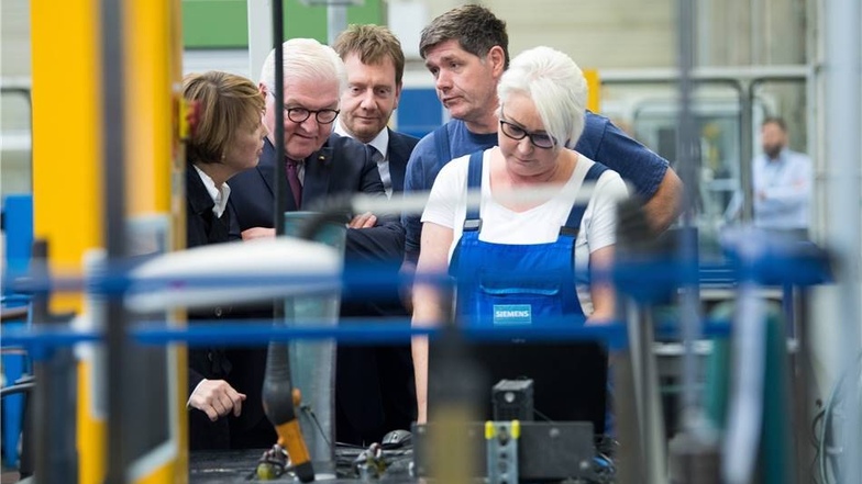 Steinmeier (2.v.l) und seine Frau Elke Büdenbender (l) und Michael Kretschmer (M, CDU), Ministerpräsident von Sachsen, sprechen beim Besuch des Görlitzer Siemens Turbinenwerkes mit den Mitarbeitern.
