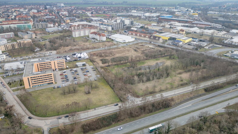 Auf dem Luftbild links ist die Agentur für Arbeit zu sehen. Neben deren Parkplatz schließt sich das schmale Grundstück an, an dessen Zuwegung auch die Müllablagerungen zu erkennen sind. Rechts von diesem Grundstück folgt die Ausgleichsfläche für Naturschu