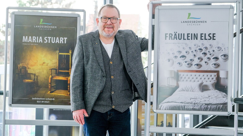 Zwischen zwei von der KI generierten Plakaten: der Marketingchef der Landesbühnen Sachsen Steffen Wollmerstädt.