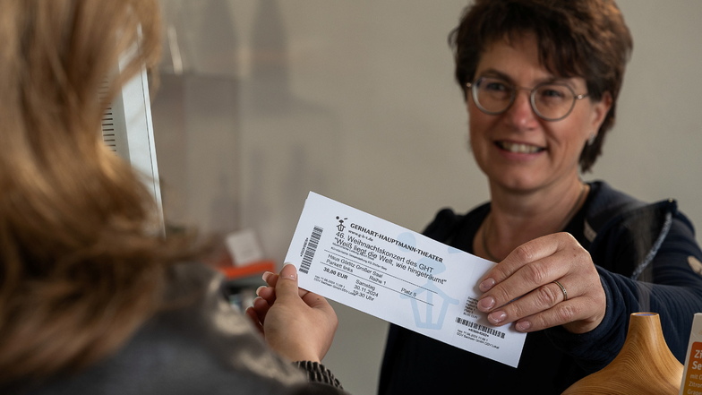 Diana Menzel, Mitarbeiterin im DDV-Lokal am Görlitzer Obermarkt, übergibt einer Kundin ihre gekauften Theater-Karten.