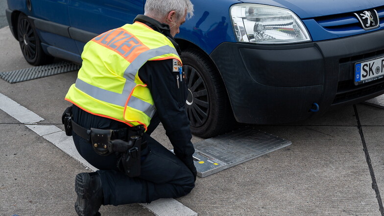 Ein Polizist positioniert eine Waage zum Wiegen eines Pkw bei einer Kontrolle. Hat das Auto unter 10 Prozent Übergewicht, darf es meistens weiterfahren.