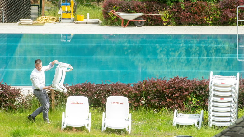 Das Bilzbad in Radebeul ist für die neue Freibadsaison vorbereitet und sbf-Geschäftsführer Titus Reime stellt Liegestühle neben dem Inselbecken für die ersten Badegäste auf.