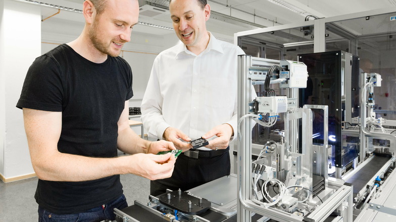 In der neunten Etage der HTW Dresden steht seit drei Jahren eine moderne Fabrik im Mini-Format. Dort zeigen Dirk Reichelt (r.) und sein Team, wie die digitalisierte Industrie der Zukunft funktioniert.