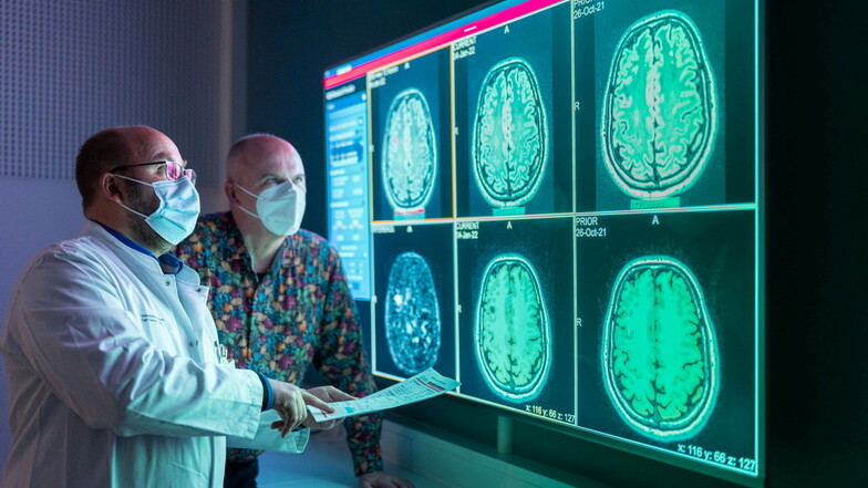 Vorher, nachher: Dr. Hagen Kitzler (links) erklärt Frank Borchard anhand von MRT-Aufnahmen, wie sich die Läsionen in seinem Gehirn innerhalb von neun Monaten verändert haben.