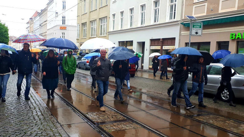 Bei strömendem Regen fand am Montag der Protest-Spaziergang in Görlitz statt, der unter anderem über die Berliner Straße führte. Mittig im Bild ist AfD-Stadtrat Jens Jäschke zu sehen.