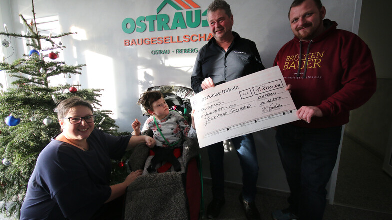 Janine (links) und Ingolf Stuber (rechts) erhalten für die Therapie ihrer Tochter Josefine einen Scheck von Ralf Stephan, dem Chef der Ostrauer Baugesellschaft.