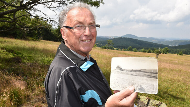 Werner Burock steht im Grünen, im Hintergrund Kohlhaukuppe und Geisingberg. An sein Dorf Vorderzinnwald in Tschechien erinnern nur noch Fotos.