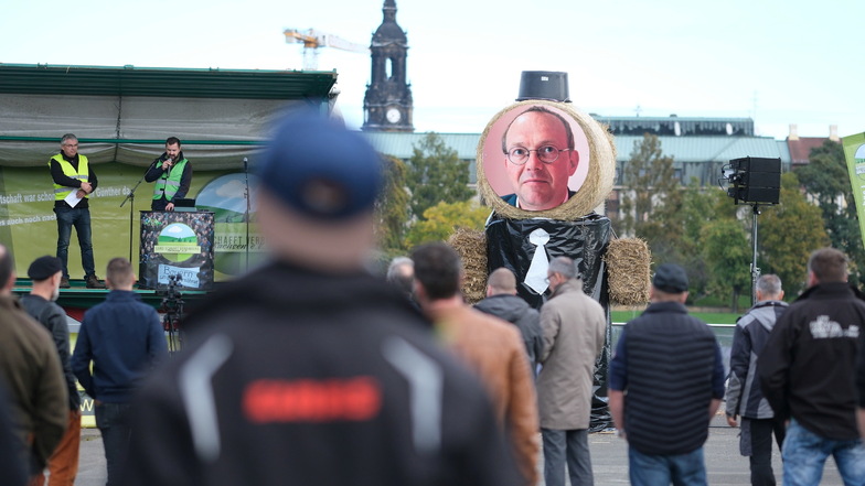 Wegen der angekündigten Verzögerungen bei der Auszahlung von Fördergeldern protestierten sächsische Bauern  auch vor dem Landtag in Dresden. Mit dabei: Ein Porträt von Landwirtschaftsminister Wolfram Günther (Grüne), das an einer Strohfigur befestigt ist.