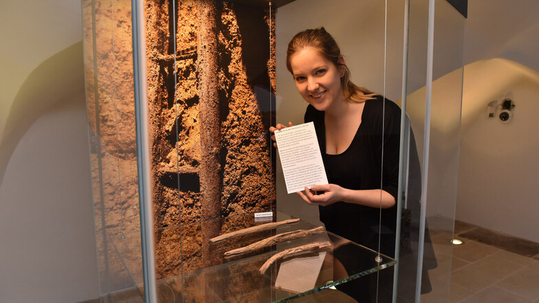 Linda Burghardt dekoriert die Vitrine mit den neuen Funden im Museum für den mittelalterlichen Bergbau in Dipps. Vor ihr liegen verbogene Hölzer, die nicht konserviert wurden.