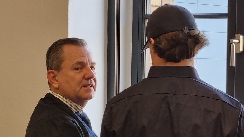 Verteidiger Michael Sturm bespricht sich mit seinem Mandanten Jan E. (r.) beim Prozessauftakt im Landgericht Dresden. Der Angeklagte soll sich 2020 als Polizist einem Kumpel als Drogenkurier zur Verfügung gestellt haben.