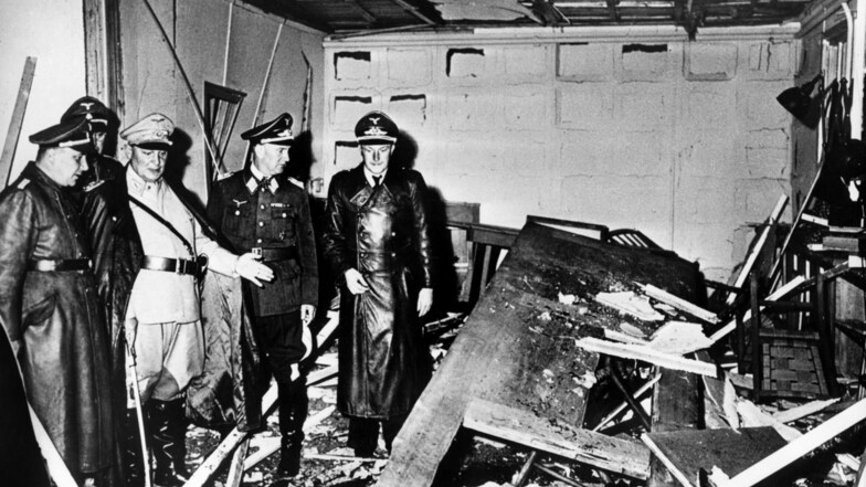 Reichsmarschall Hermann Göring (helle Uniform) und der Chef der "Kanzlei des Führers", Martin Bormann (li.), begutachten die Zerstörung der Karten-Baracke im Führerhauptquartier nach dem Sprengstoff-Attentat auf Hitler.