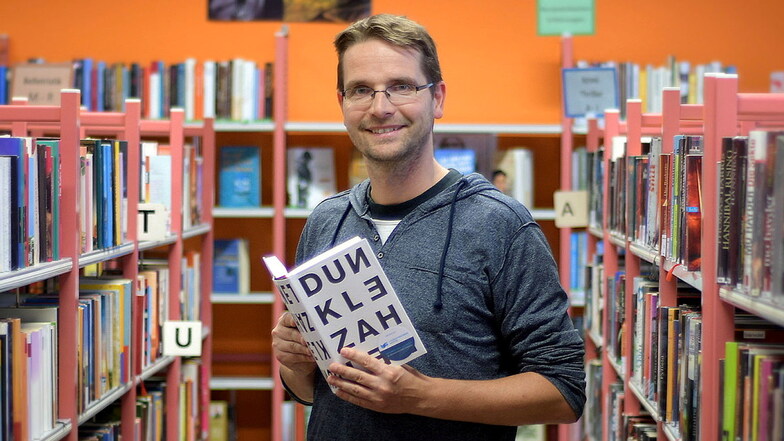 Leiter Michael Diezel steht an einem Bücherregal in der Waldheimer Bibliothek. Die Nutzer greifen aber immer häufiger zu Spielen und DVDs.